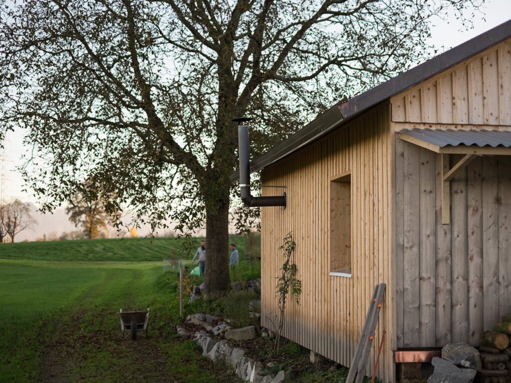 Gemütliche Sitzecke im Garten umgeben von blühenden Beeten